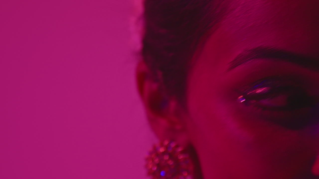 cerca de la cara y las joyas de la bailarina de kathak que realiza el baile vestida con el vestido tradicional indio contra un fondo púrpura