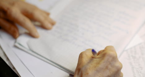 senior businessman writing on paper at table in office 11