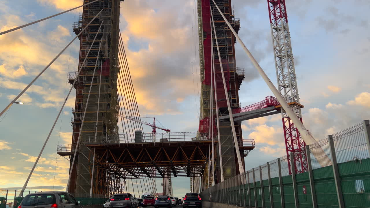 Cars driving over The Constitution of 1812 Bridge, La Pepa Bridge in the south of Spain, the Bay of Cadiz, blue sky and yellow clouds, new architecture, 4K shot