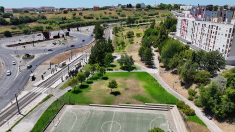 tomada de un dron de un pequeño parque junto a una parada de tranvía en monte de caparica