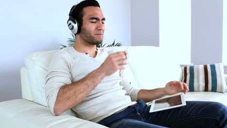 hombre escuchando música con su computadora tablet