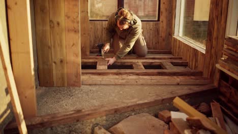 hombre poniendo suelo de madera dentro del invernadero