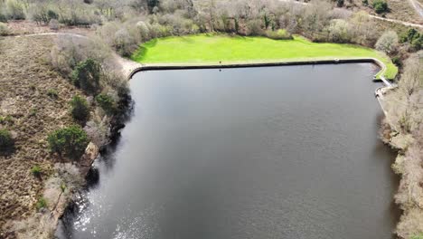 Calm-Squabmoor-Reservoir-Located-In-Woodbury-Common-In-East-Devon-With-Grass-Area-In-Background