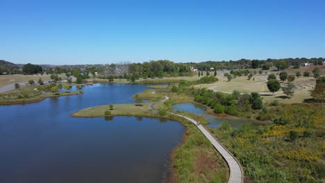 drone shot flying over fishing pond and walking path at the city of clarksville close to the marina, tennessee