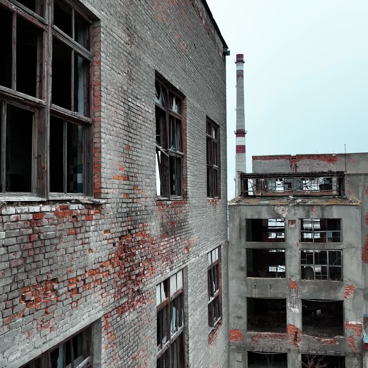 Ruined and abandoned territory of industrial plant. Buildings of an old plant destroyed with time and nature