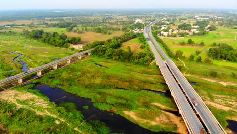 Vista-Aérea-De-La-Carretera-India-Que-Conduce-Hacia-El-Lago-En-La-Ap-India-En-Un-Día-Soleado-Durante-El-Verano-Indio