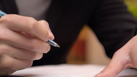 businessman taking notes or signing contract, pen and document, man in formal jacket. close up hand