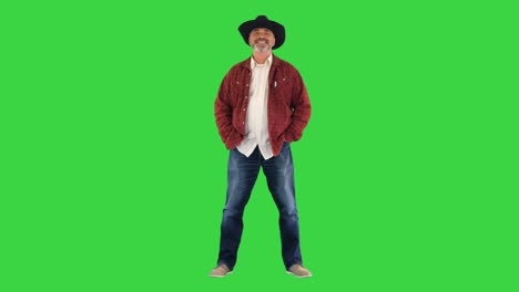 elderly caucasian man farmer agronomist in cowboy hat smiling to camera on a green screen, chroma key