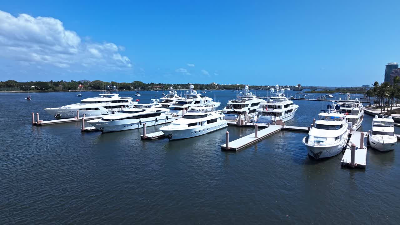 Low orbit drone shot of white yachts in West Palm Beach marina during the day in Florida, USA