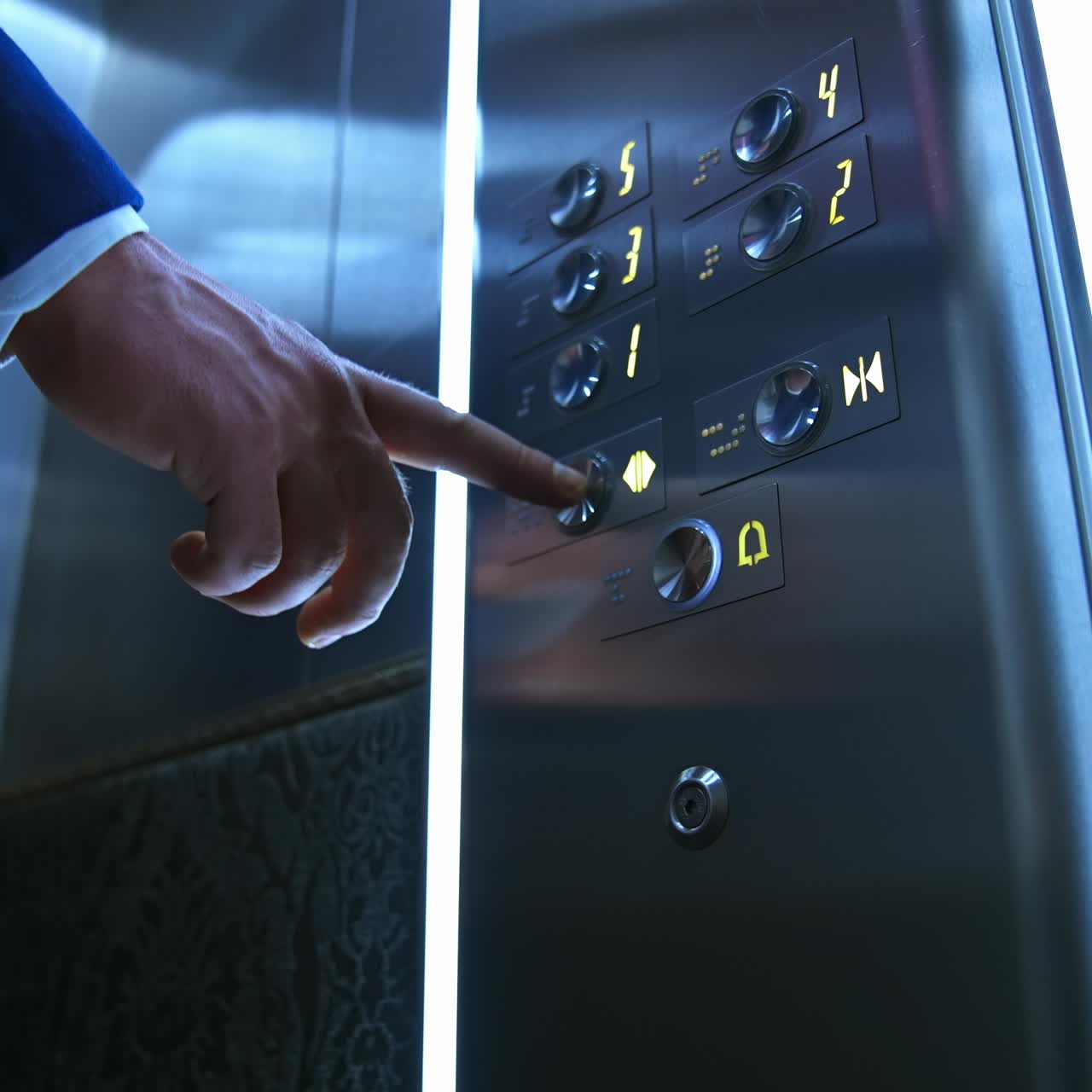 Man presses electronic button in lift. Man's hand touches elevator buttons in a hotel. Businessman in modern elevator. Close-up