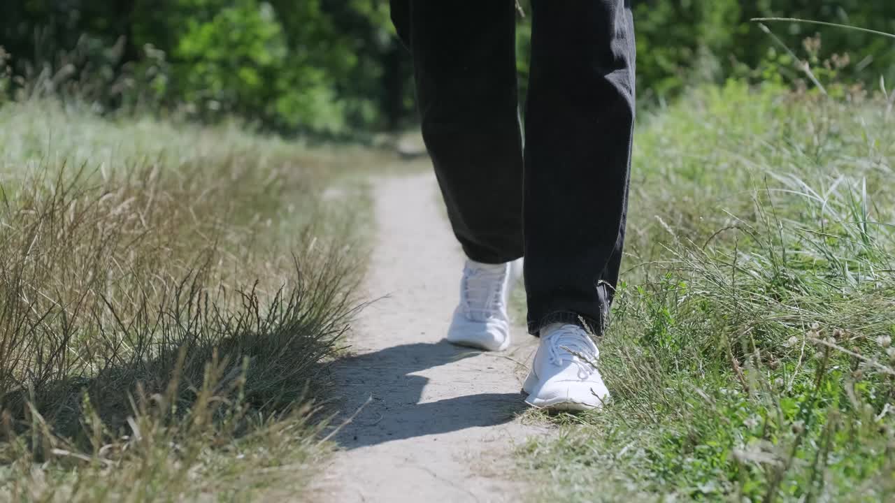 숲 근처의 거리에서 기타를 들고 는 젊은 남자