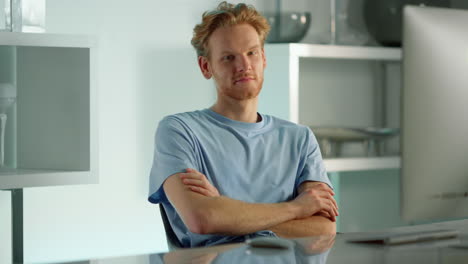 Smiling-businessman-relaxing-workplace-looking-camera-at-desktop-computer.