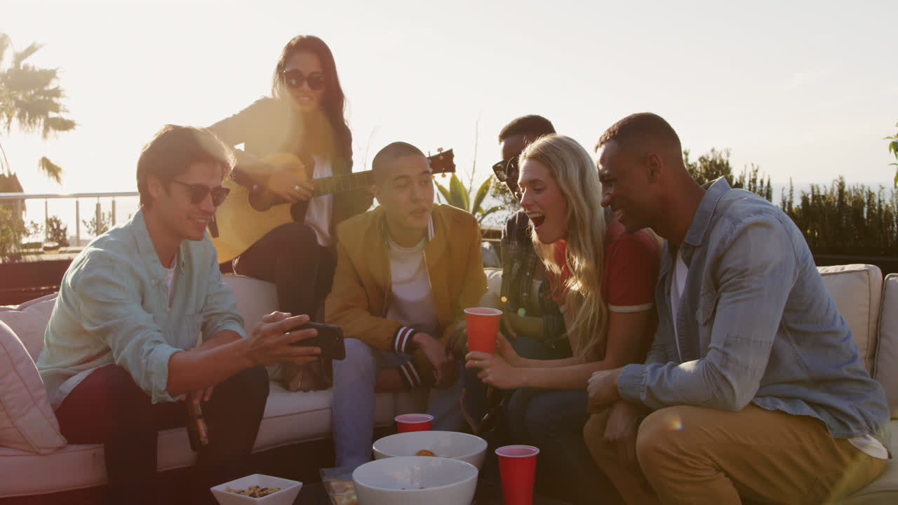 un gruppo di amici che bevono birra e discutono su un tetto