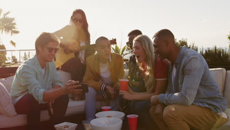 group of friends drinking beers and discussing on a rooftop