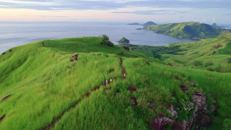 Hikers-walking-on-lush-tropical-island-summit-at-sunset,-Nacula,-Yasawa,-Fiji