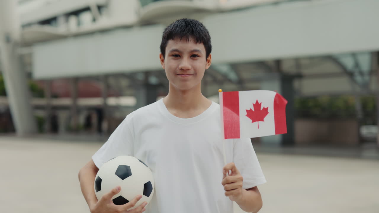 Teenager with Canadian flag and soccer ball