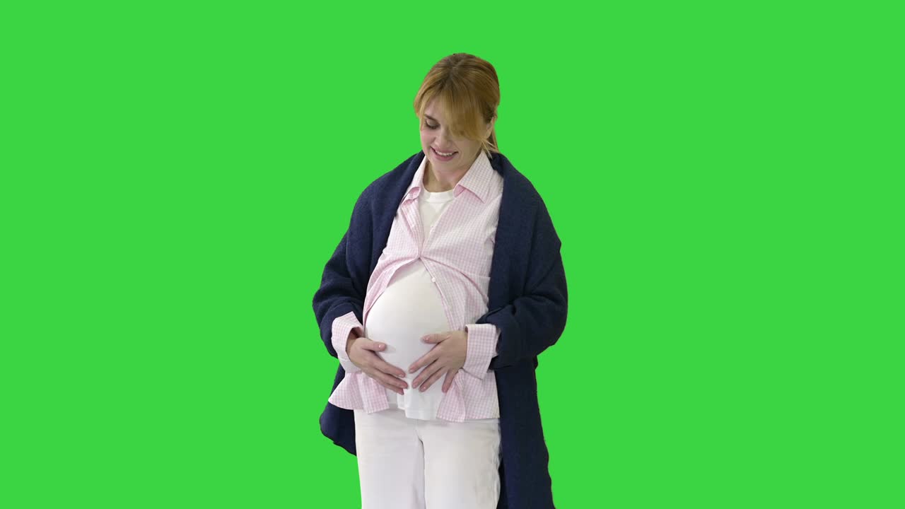 초록색 스크린, 크로마 키에서 배를 만지는 임신한 여성