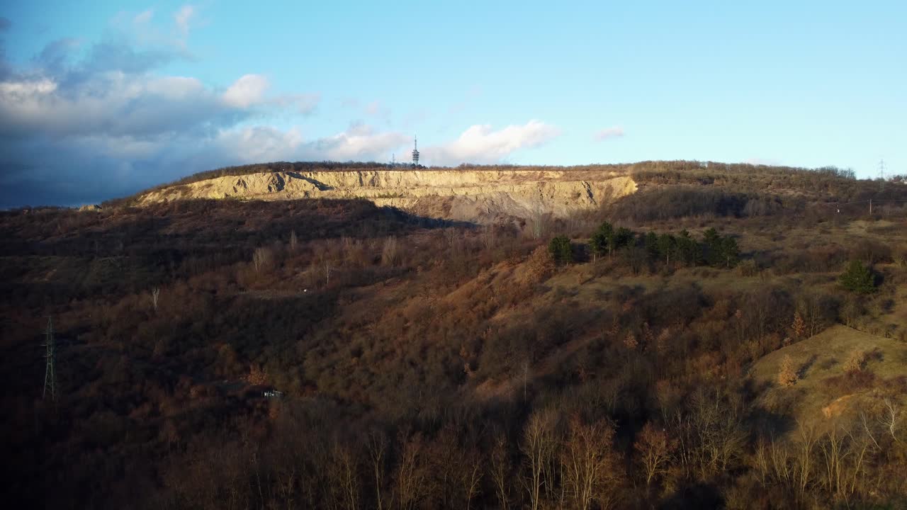 Ripresa drone rivelatrice di una grande cava con una torre per telecomunicazioni in cima.