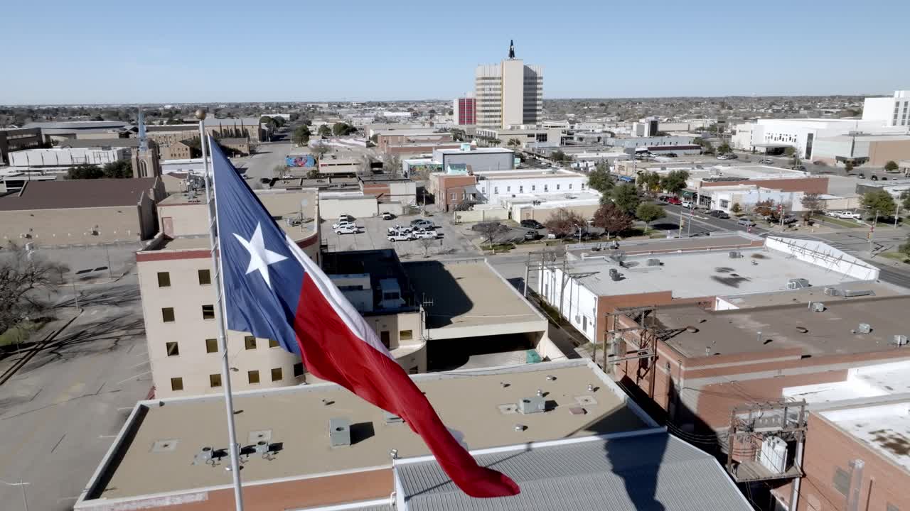 Texas state flag waving in the wind in Odessa, Texas with drone video moving forward