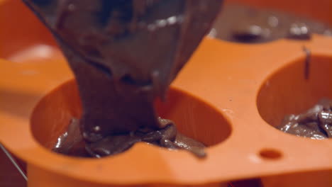 Filling-Of-Chocolate-Mixture-To-Orange-Heart-Shaped-Mould---Closeup-Shot