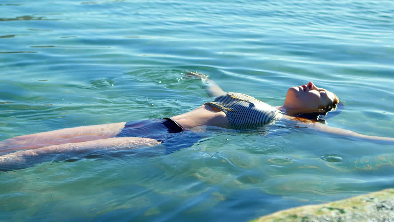 mujer nadando en el agua en la playa 4k
