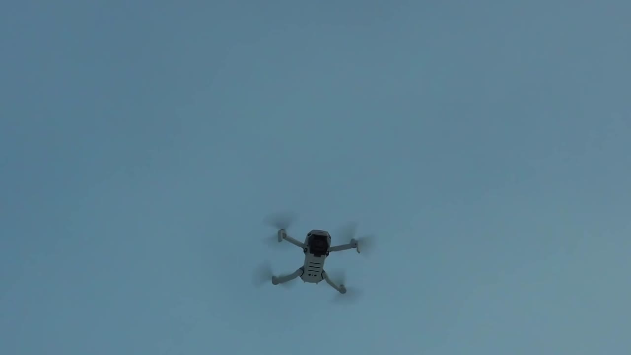 DJI drone flys above in-flight slomo wide shot