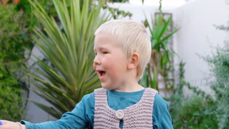 boy playing with bubble wand in garden 4k