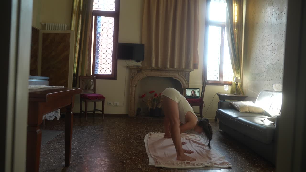 Woman practicing online yoga in a Venetian apartment