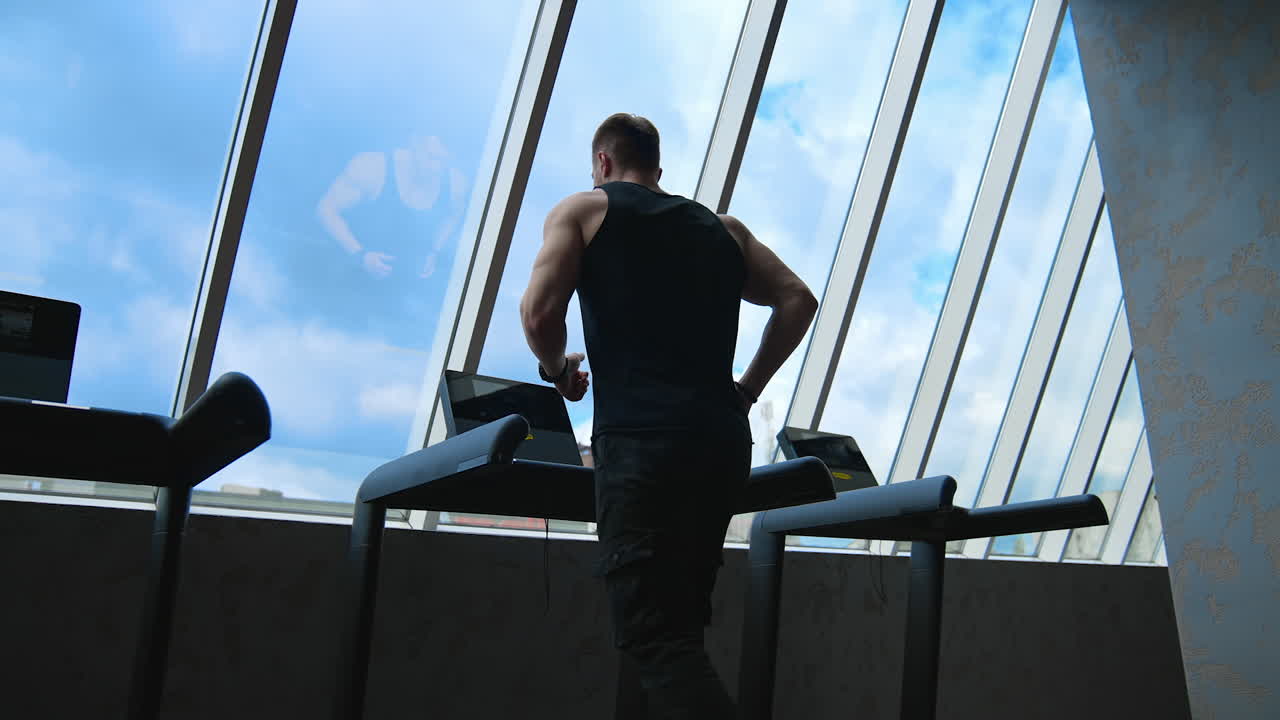 Man running on the treadmill. Athletic man running on treadmill in fitness gym