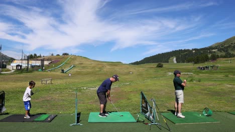 two people practicing golf at a driving range