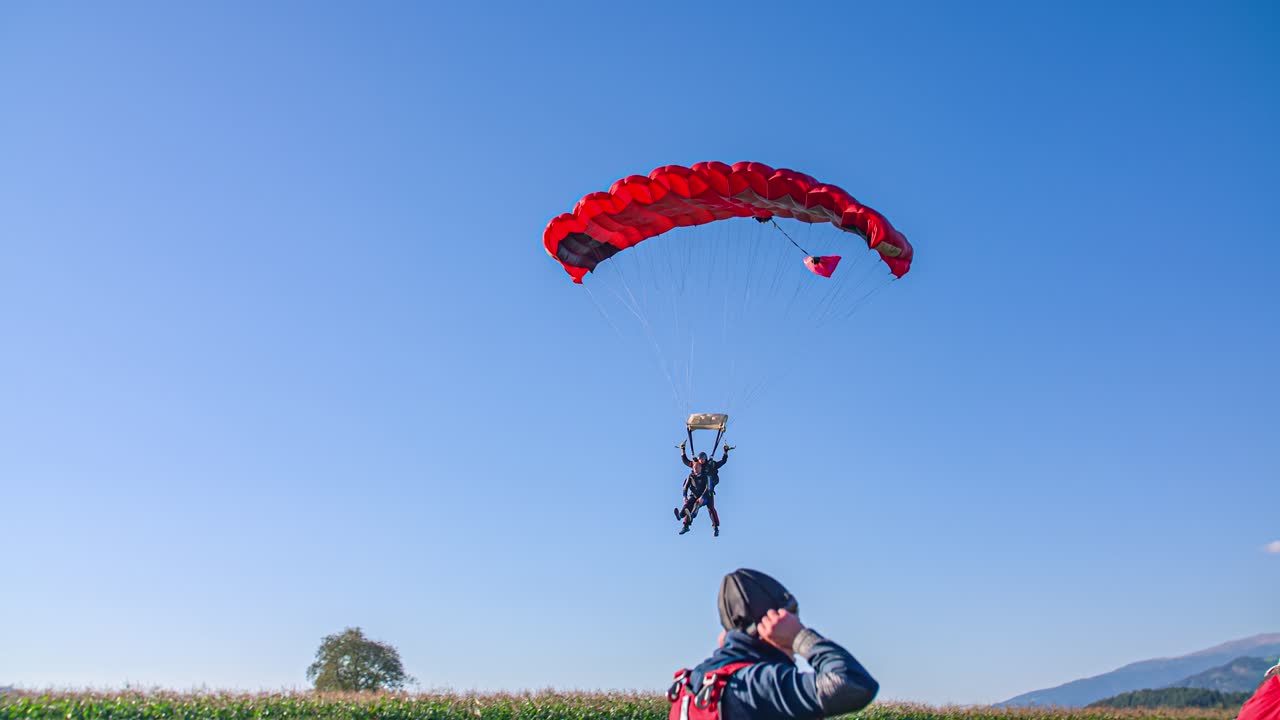 Tandem Skydivers Successfully Land Safely On The Ground By Parachute