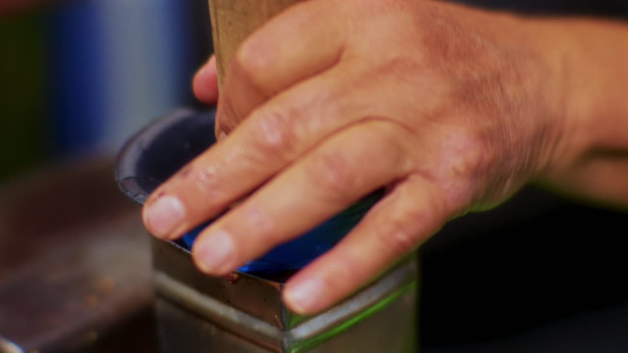 primer plano de un hombre mayor triturando manzanas con una trituradora eléctrica