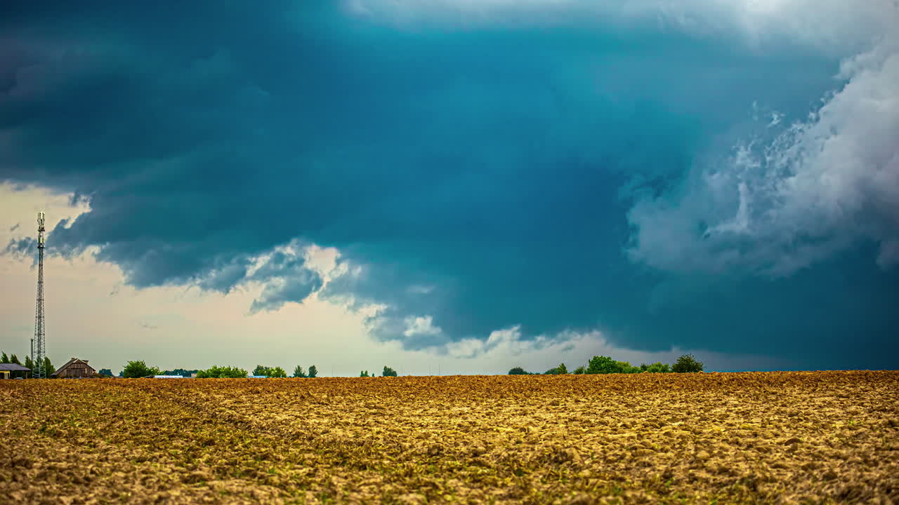 Tijdverloop van uitbreidende donkere wolkenformatie boven een platteland in Letland.