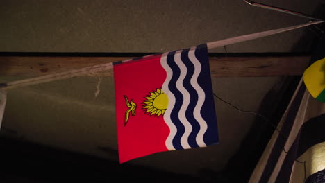 Flag-of-Kiribati-wave-inside-rural-building,-close-up