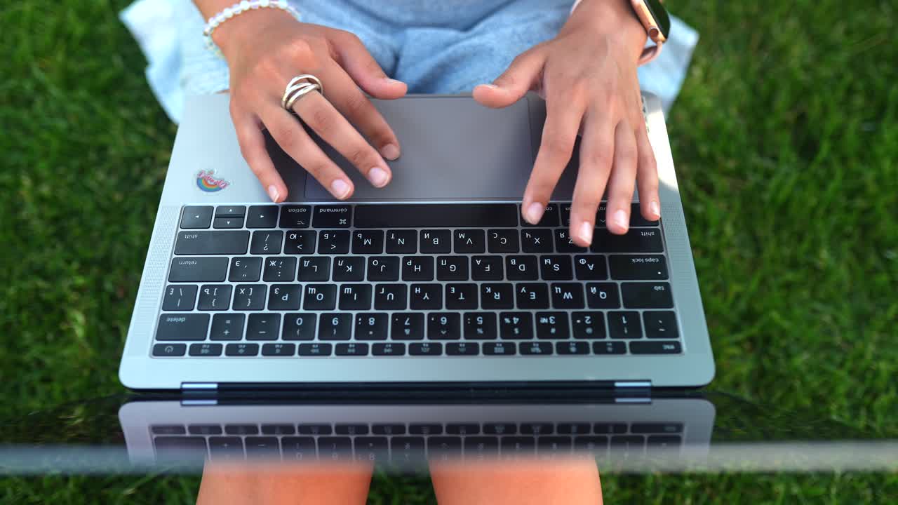 mujer escribiendo en una computadora portátil al aire libre