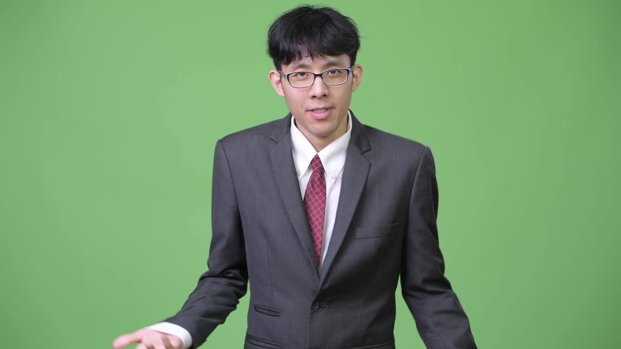 젊은 아시아 사업가 가 클립보드 를 들고 어깨 를 끄덕여 읽고 있다