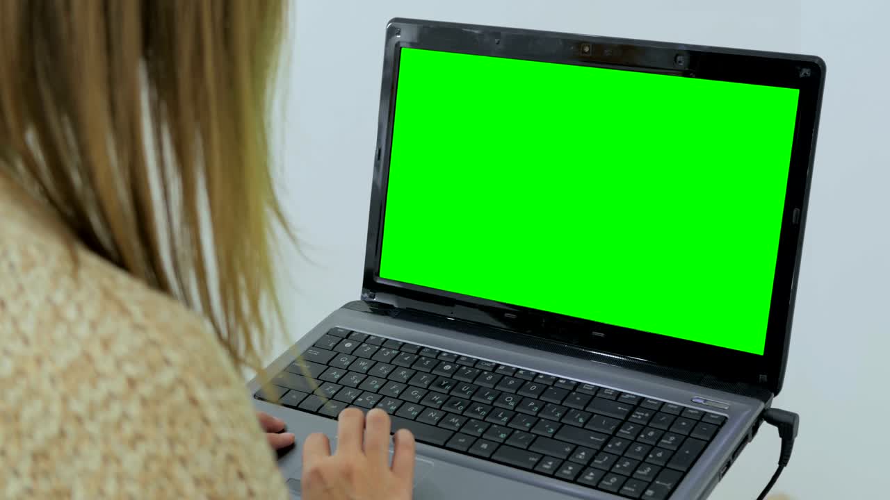 mujer usando una computadora portátil con pantalla verde