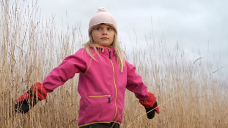 Reversed-clip-of-young-girl-in-crop-field-on-a-cold-autumn-day