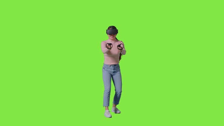 Inquadratura a figura intera di una donna che indossa un visore per la realtà virtuale e gioca contro uno sfondo da studio con schermo verde