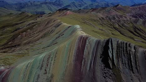 aerial, tilt, drone shot overlooking the palcoyo rainbow mountain, in valle rojo, or red valley, sunny day, in andes, peru, south america