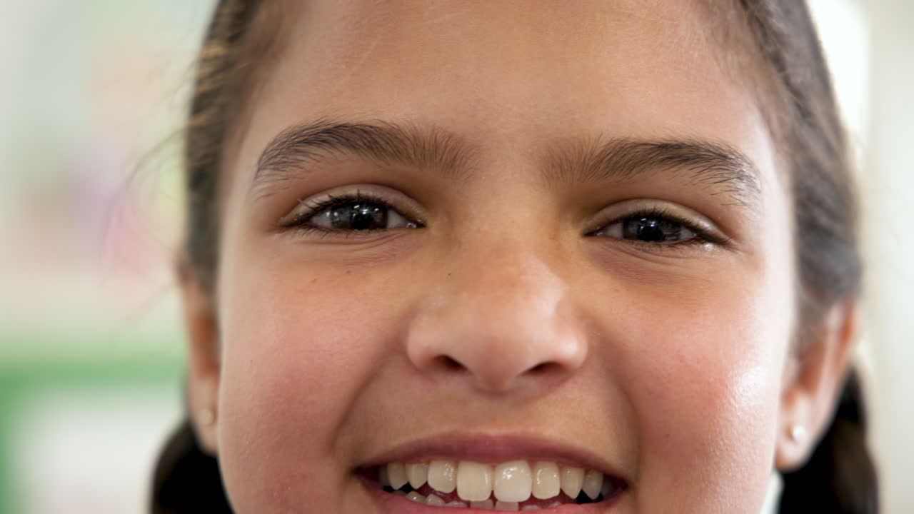 Smiling girl in school, close-up of joyful expression and bright eyes