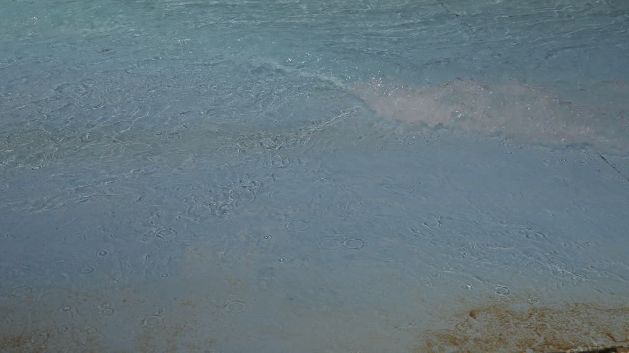 Rolling waves moving across swimming pool surface at Praia das Rocas