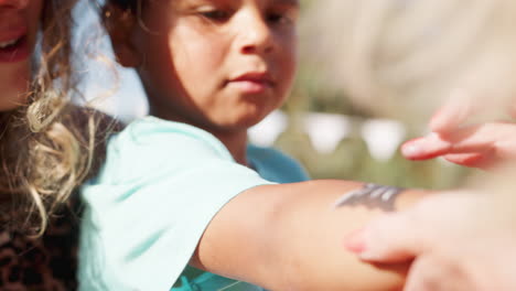 disparo en cámara lenta de un niño joven con su madre en un puesto de pintura facial en la fiesta del jardín de verano