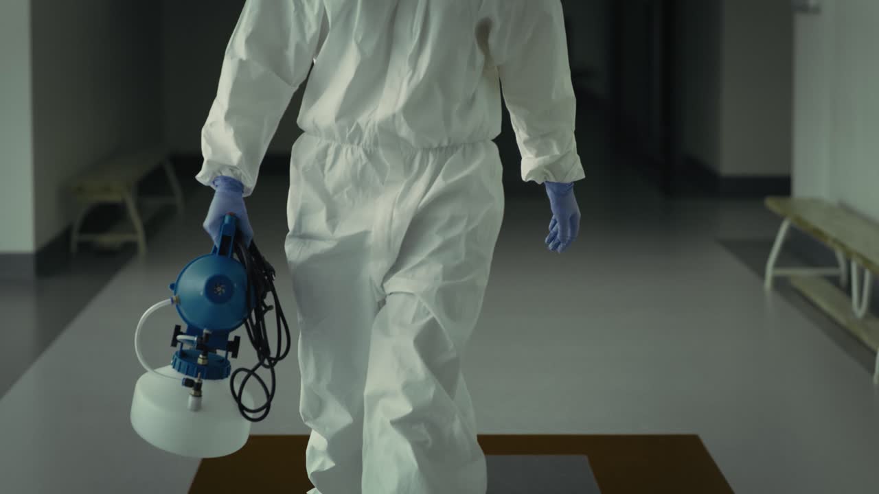 video inclinado hacia abajo del trabajador de saneamiento caminando por el pasillo