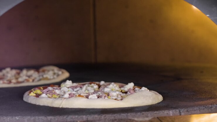 Primo piano di pizza italiana in cottura nel forno