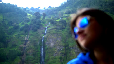 view of a woman wearing glasses in front of waterfall devil's cauldron