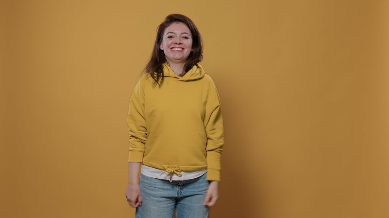 Woman celebrating success in yellow hoodie