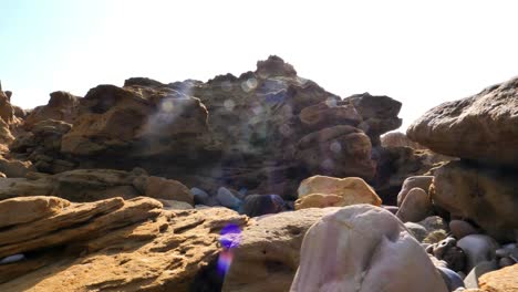 paisaje árido de rocas rocosas en baluchistán bajo la dura luz del sol con destello de lente