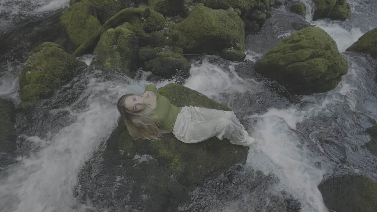 Woman relaxing by a waterfall
