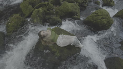 woman relaxing by a waterfall